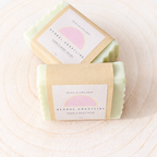 Two bars of soap with 'Herbal Coastline' labels on a textured beige background
