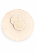 two off white loofah circle shaped on circle wood board and white background