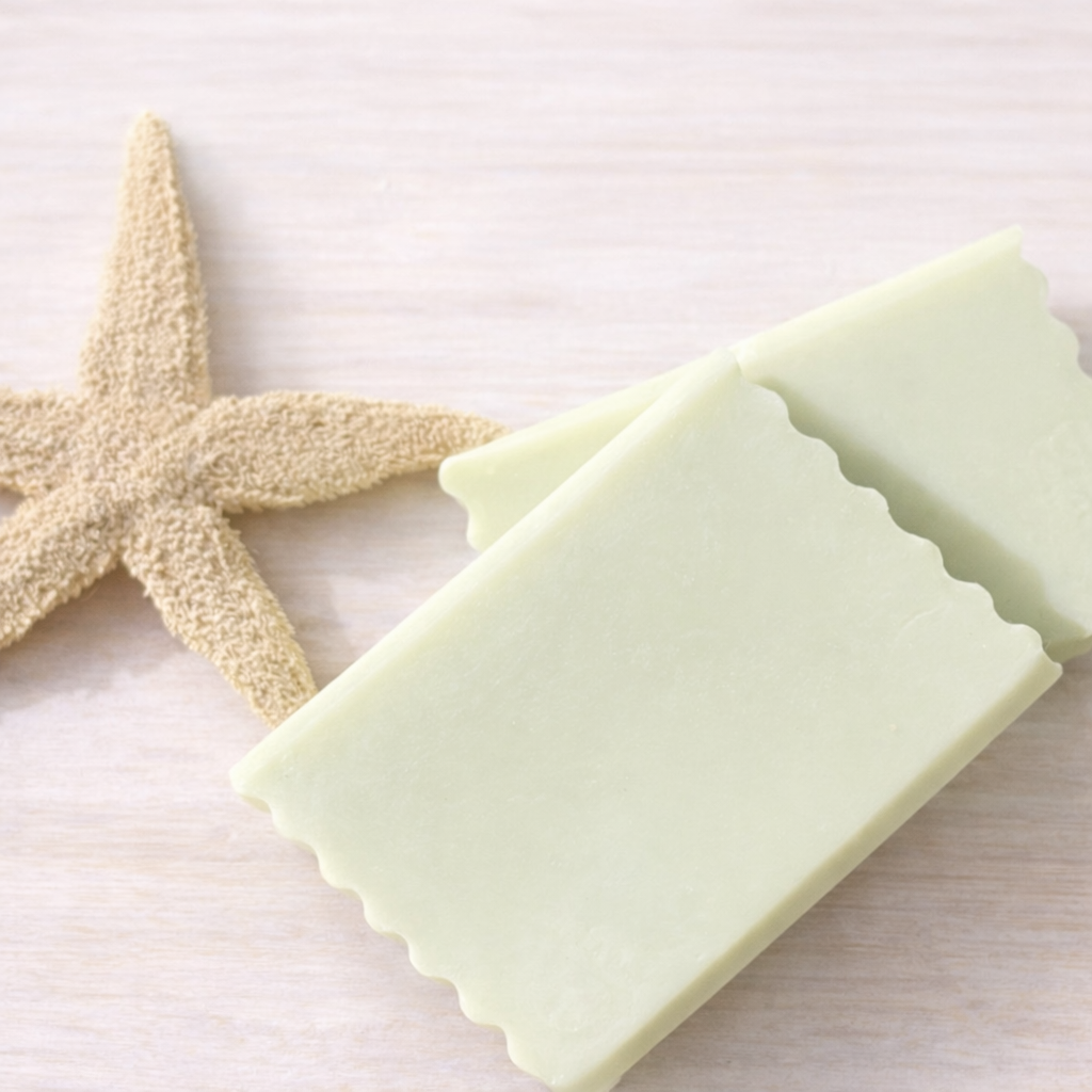 Two bars of light green soap with a starfish on a white background