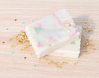 two celebration bars on a wood background with gold crinkle paper and confetti