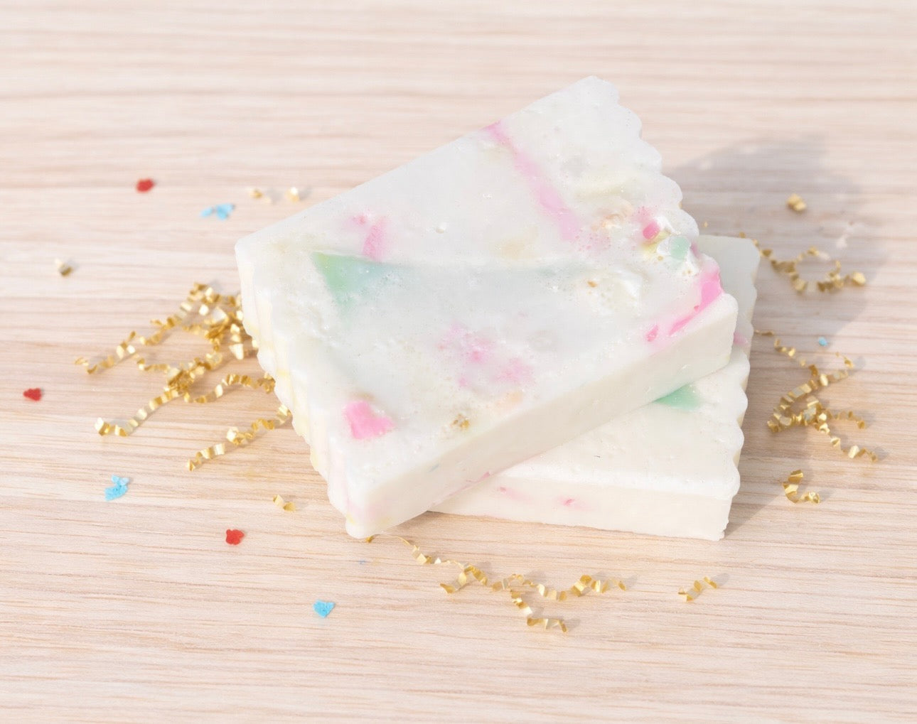 two celebration bars on a wood background with gold crinkle paper and confetti