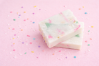 soap scrap piece two celebration bars of soap with pink background scattered with colourful sprinkles