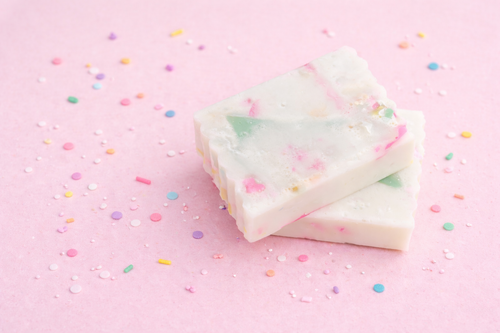 soap scrap piece two celebration bars of soap with pink background scattered with colourful sprinkles