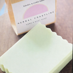 Bar of soap with packaging labeled 'Herbal Coastline' on a wooden surface