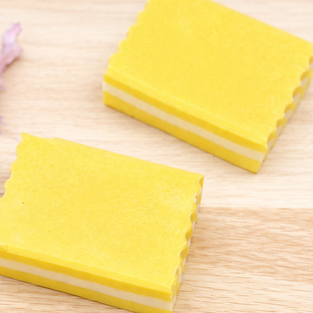 Two yellow square blocks of soap on a wooden surface